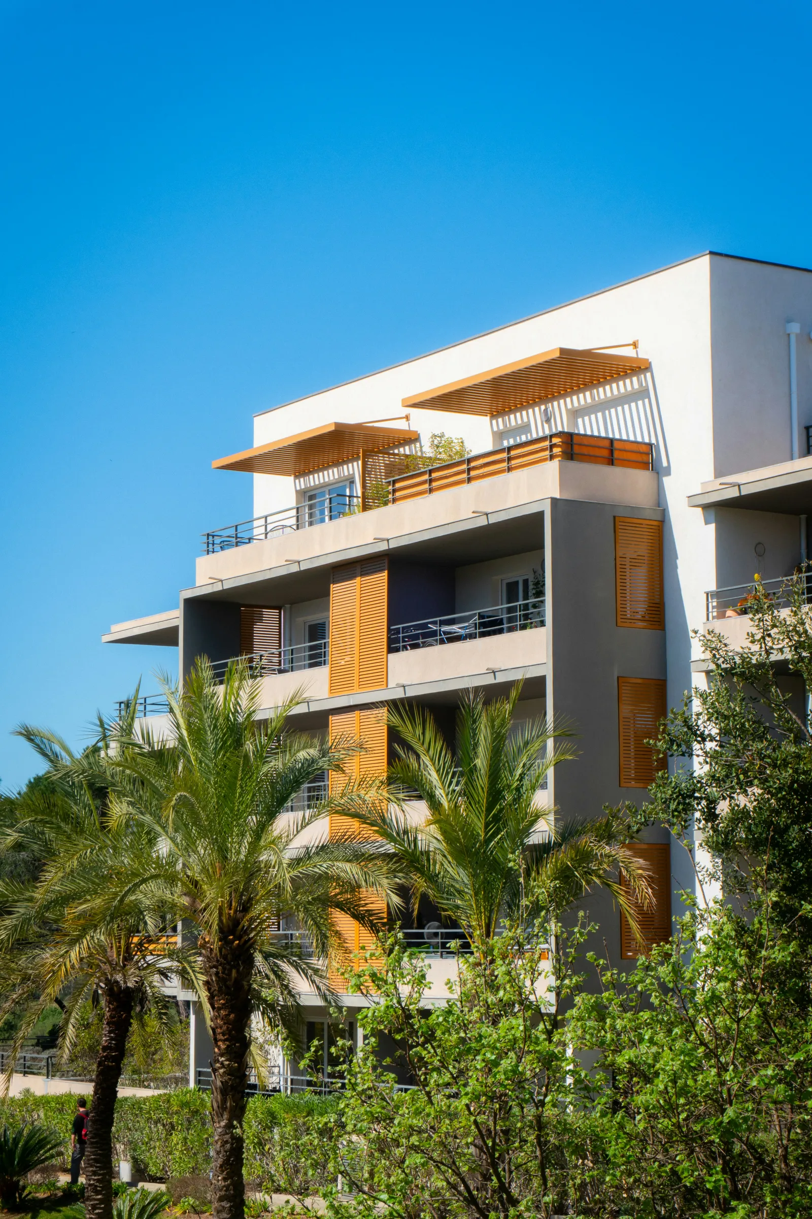 Modern apartment complex exterior with landscaped grounds and parking